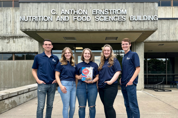 The cotta tots product development team holds their product in front of the NFS building.